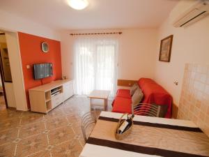 - un salon avec un canapé rouge et une télévision dans l'établissement Apartments with a parking space Vinkuran, Pula - 21016, à Medulin