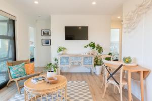 uma sala de estar com uma mesa e uma televisão em Grace Road Getaway em Tauranga