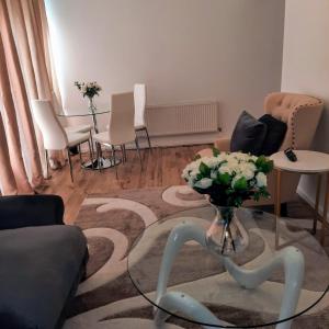 a living room with a table with a vase of flowers at Quality space in Havering atte Bower