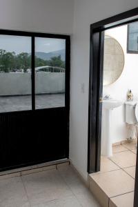 a bathroom with a black door and a sink at Rá Ngu in Ixmiquilpan