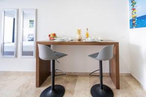 une table en bois avec deux tabourets sous celle-ci dans l'établissement Midtown 2 by Andiani Travel, à Playa del Carmen 53 autres photos
