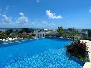 - une grande piscine bleue au-dessus d'un bâtiment dans l'établissement Midtown 2 by Andiani Travel, à Playa del Carmen