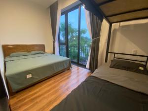 2 Betten in einem Schlafzimmer mit Balkon in der Unterkunft Ju’s House in Dong Hoi