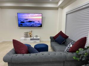 a living room with two couches and a flat screen tv at Treasure in Brant - 4 Bedroom Detached House in Paris