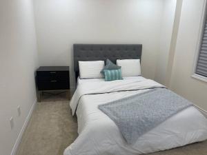 - une chambre avec un lit doté d'une tête de lit grise et d'oreillers dans l'établissement Treasure in Brant - 4 Bedroom Detached House, à Paris