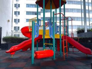 um parque infantil com um escorrega vermelho num edifício em b.suites 21 em Kota Kinabalu