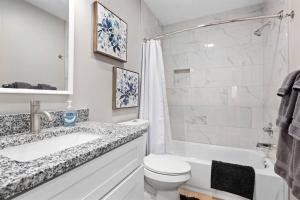 ein Badezimmer mit einer Badewanne, einem WC und einem Waschbecken in der Unterkunft Brand New 1BR Flat, Cozy King Suite in Mount Clemens