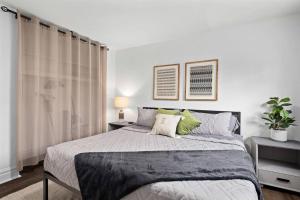 ein Schlafzimmer mit einem großen Bett mit grünen Kissen in der Unterkunft Brand New 1BR Flat, Cozy King Suite in Mount Clemens