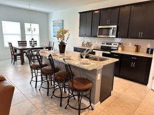 uma cozinha com uma grande ilha numa cozinha com uma mesa em * Brand New Vacation Home * em Haines City
