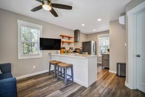 a kitchen with a bar and two stools at The Bluffton Village Home - 5 BR in Old Town w Carriage Home in Bluffton