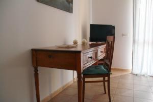 a desk with a television and a chair in a room at B&B La Rosa Blu in Bari