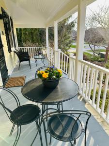 a table on a porch with a vase of flowers on it at Heritage House Niagara in Niagara on the Lake