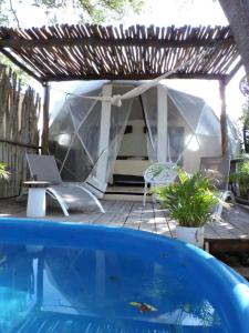 a swimming pool with a tent and a table and a chair at Glamping Tulum with private mini pool in Tulum
