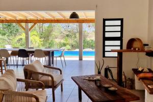 a living room with a table and chairs and a pool at Kazacactus-villa 3 chambres piscine Marie-Galante in Beauséjour +14 photos
