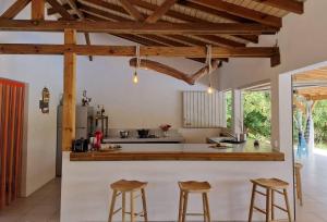 uma cozinha com tectos em madeira e um balcão com bancos em Kazacactus-villa 3 chambres piscine Marie-Galante em Beauséjour