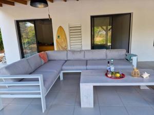 un sofá sentado en un patio con una bandeja de comida en Kazacactus-villa 3 chambres piscine Marie-Galante, en Beauséjour
