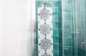 y baño con ducha de azulejos verdes y blancos. en B&B DieMme Amalfi Coast en Vietri