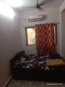 a bedroom with a bed with a curtain and a window at Sky Cottage Matheran in Matheran