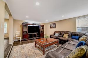 a living room with leather couches and a tv at Nash Boulevard Hideaway in San Antonio