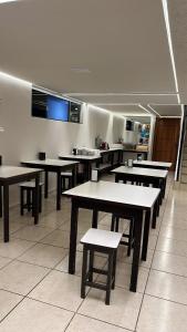 a cafeteria with tables and benches in a room at Hotel Pires Faxinal in Faxinal