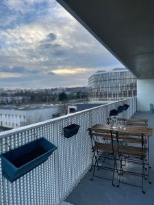 balkon ze stołem i krzesłami na budynku w obiekcie Gorgeous Apartment near Paris & Disneyland w mieście Fontenay-sous-Bois