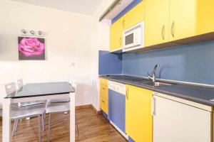 a kitchen with yellow and blue cabinets and a sink at Ideal familias zona infantil y vistas a pistas in Candanchú