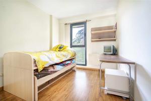 a small bedroom with a bed and a desk at Ideal familias zona infantil y vistas a pistas in Candanchú