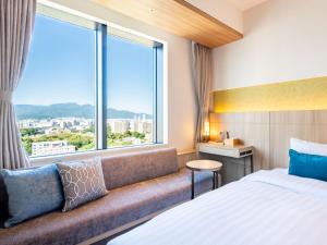 a hotel room with a bed and a large window at Keio Prelia Hotel Sapporo in Sapporo