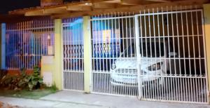 a white gate with a car in a garage at Brisa del Cielo in Salta