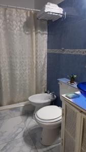 a bathroom with a white toilet and a sink at Brisa del Cielo in Salta +13 photos