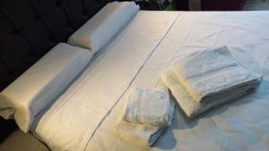 a white bed with two folded towels on it at Brisa del Cielo in Salta