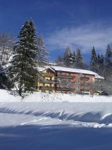 a large building in the snow in front at Hotel Miramonti in Bedollo