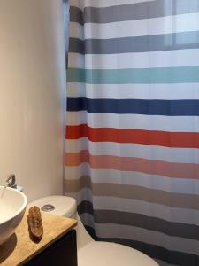 a bathroom with a toilet and a shower curtain at Casa Familiar Reserva Humedal in El Convento