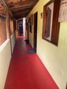 um corredor vazio com um piso vermelho num edifício em Pousada Pituba em Itacaré