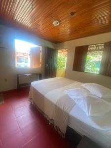 um quarto com uma cama grande e um tecto em madeira em Pousada Pituba em Itacaré