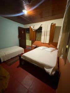 um quarto com 2 camas e uma janela em Pousada Pituba em Itacaré