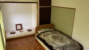 Dormitorio pequeño con cama y espejo en Guest House Yasuragi Kamigoto - Vacation STAY 45616v, en Shinkamigoto