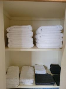 tres pilas de toallas en un estante en un armario en The Perfect Getaway (5 mins from Eugene Airport) en Eugene