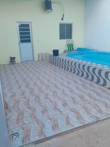 a room with a large rug next to a pool at Casa Temporada, jequia in Jequia da Praia