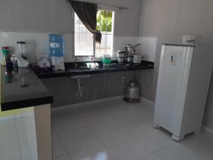 a kitchen with a white refrigerator and a window at Casa Temporada, jequia in Jequia da Praia