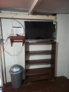 a tv on a shelf in a room at Casa del bosque 
