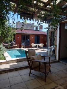 een patio met een tafel en stoelen en een zwembad bij Casona Veroka in San Pedro