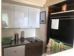 eine Küche mit einer schwarzen Mikrowelle und einem Herd oberen Backofen in der Unterkunft Appartement 2 pièces cosy au centre-ville, à 2 pas de la plage avec parking - FR-1-712-35 in Villers-sur-Mer