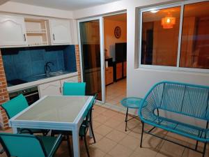 cocina y comedor con mesa y sillas en Cibuqueira numéro 5, Appartement en centre ville,vue sur mer, plage à pied en Le Moule