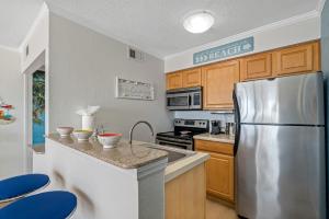 uma cozinha com um frigorífico de aço inoxidável e armários de madeira em Paradise Beach Sailport Resort Condo em Tampa