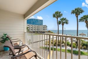 balcón con 2 sillas y vistas a la playa en Paradise Beach Sailport Resort Condo en Tampa