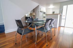 a dining room with a glass table and chairs at Plover Executive Deluxe Villa 25 in Cams Wharf