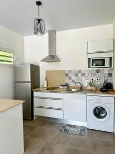 a kitchen with a sink and a refrigerator at La Villa Louisia in Matoury