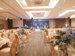 a banquet hall with tables and chairs with flowers at Green Hotel and Resort in Khon Kaen