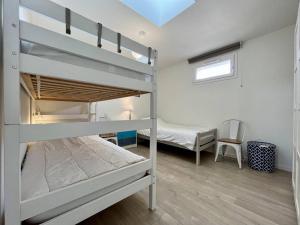 sypialnia z 2 łóżkami piętrowymi i krzesłem w obiekcie Maison La Brée-les-Bains, 3 pièces, 4 personnes - FR-1-246A-223 w mieście La Brée-les-Bains